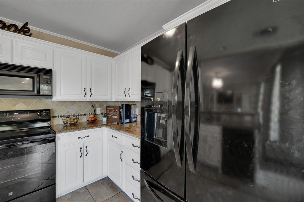 951 Behrens Court Crowley, TX 76036 - Photo 16 of 37 a kitchen with a refrigerator and a stove top oven