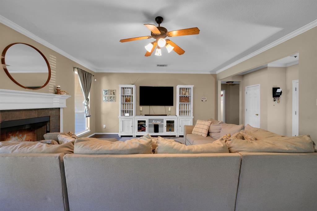 951 Behrens Court Crowley, TX 76036 - Photo 20 of 37 a living room with fireplace furniture a flat screen tv and a chandelier
