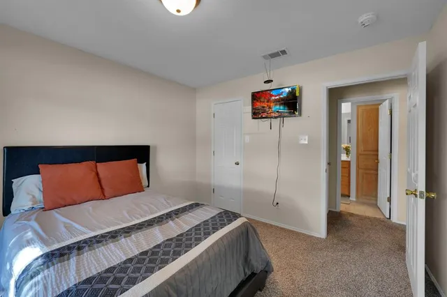 a bedroom with a bed and a painting on the wall