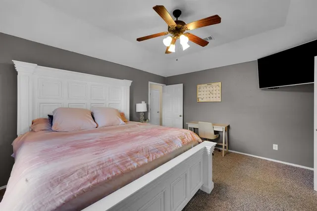a bedroom with a large bed and a flat tv screen on a dresser
