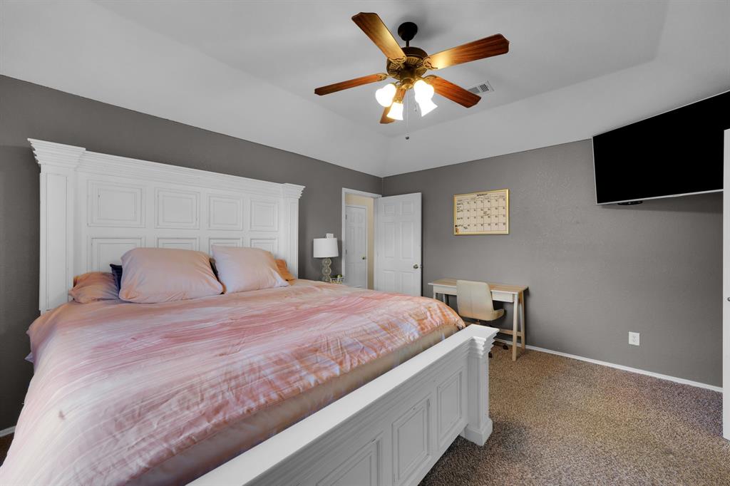 951 Behrens Court Crowley, TX 76036 - Photo 6 of 37 a bedroom with a large bed and a flat tv screen on a dresser