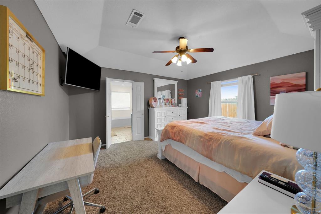 951 Behrens Court Crowley, TX 76036 - Photo 7 of 37 a spacious bedroom with a bed and a chandelier