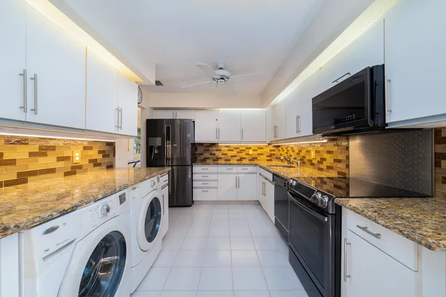 a front view of a house with a garden and tree