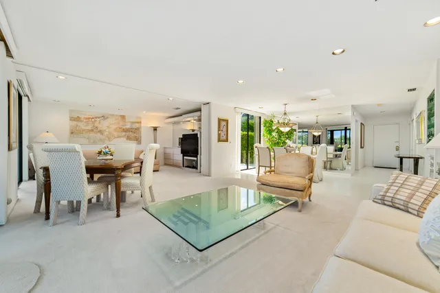 a view of a dining room with furniture a chandelier and a large window