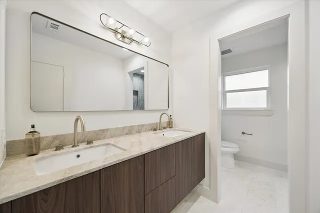 a bathroom with a double vanity sink and a mirror