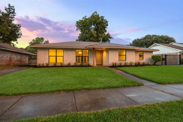 a front view of a house with a garden and yard