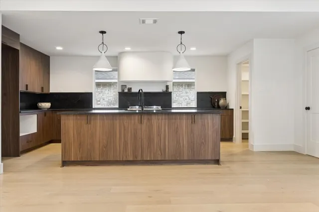 a kitchen with stainless steel appliances kitchen island granite countertop a stove a sink and a refrigerator