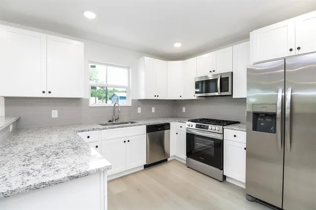 a kitchen with stainless steel appliances granite countertop a sink stove and refrigerator