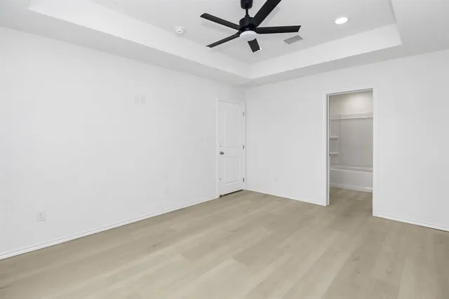 an empty room with a ceiling fan and window