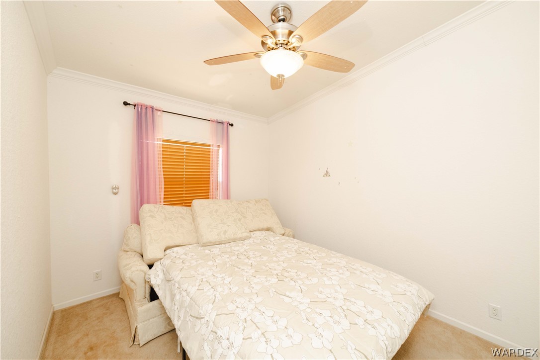 3190 East Pepper Tree Road Kingman, AZ 86409 - Photo 22 of 67 a bedroom with a bed and a chandelier
