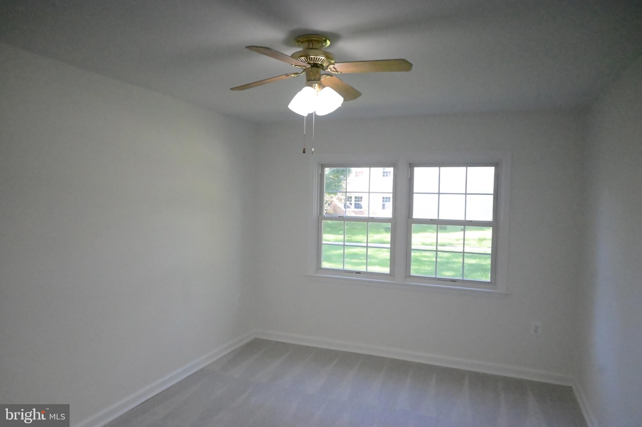 9451 Fairfax Boulevard, Unit 102 Fairfax, VA 22031 - Photo 12 of 26 an empty room with a window and a ceiling fan