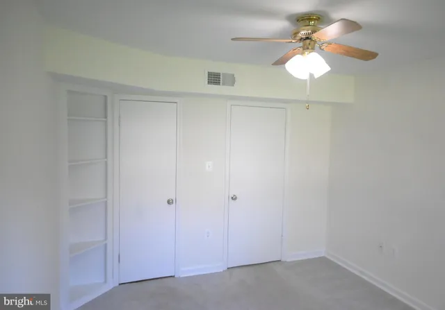 wooden floor in a hall with a chandelier fan