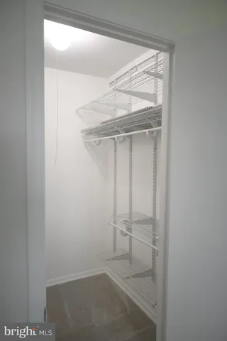 an empty room with a chandelier fan and windows