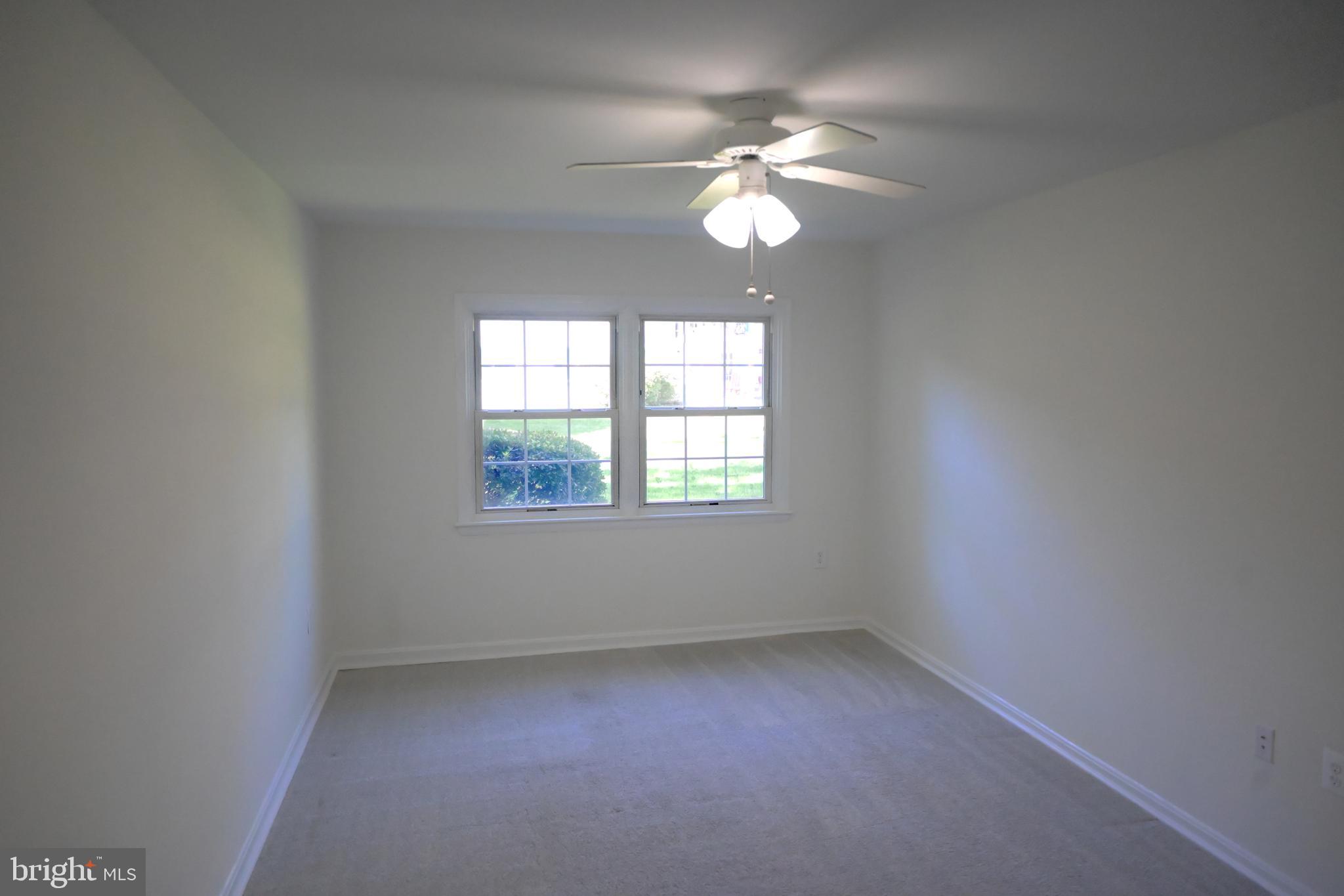 9451 Fairfax Boulevard, Unit 102 Fairfax, VA 22031 - Photo 17 of 26 an empty room with a chandelier fan and windows