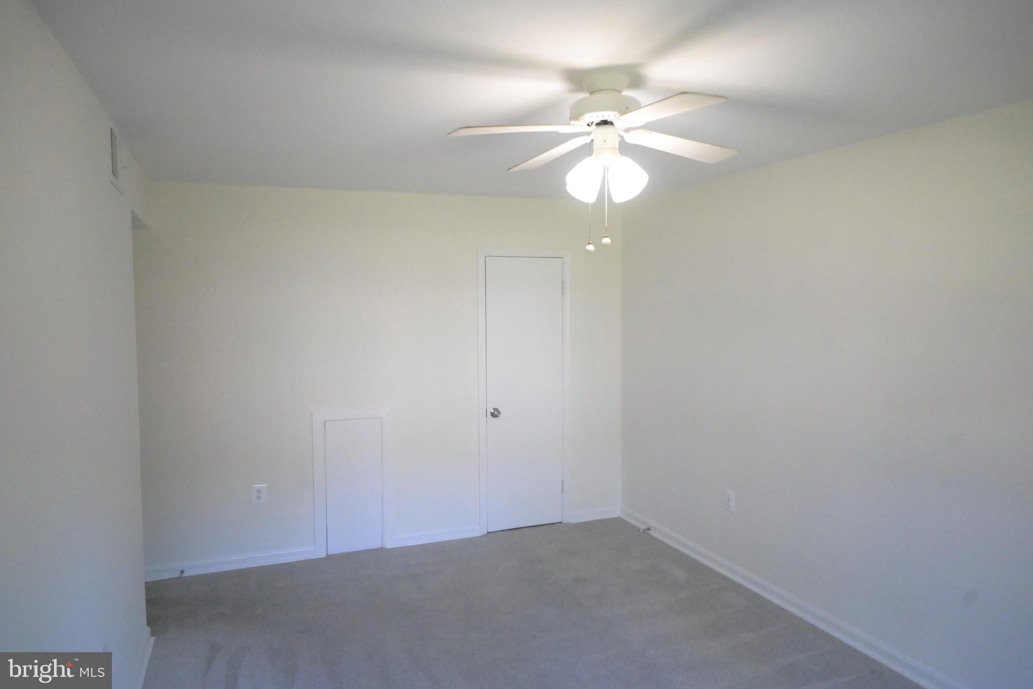 9451 Fairfax Boulevard, Unit 102 Fairfax, VA 22031 - Photo 18 of 26 an empty room with a chandelier fan and windows