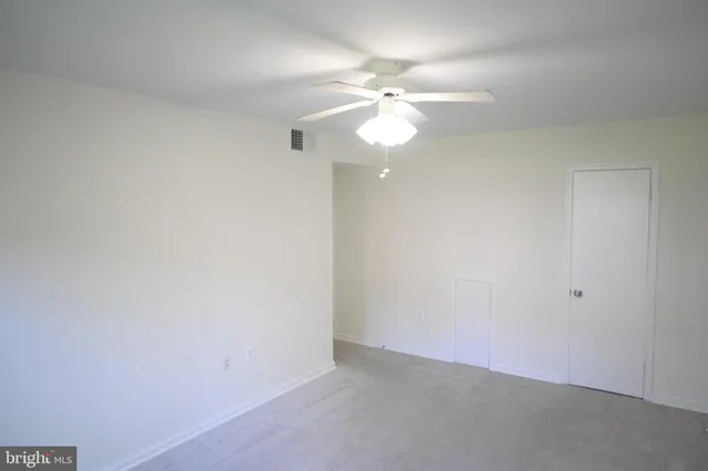 an empty room with a fan and a fan