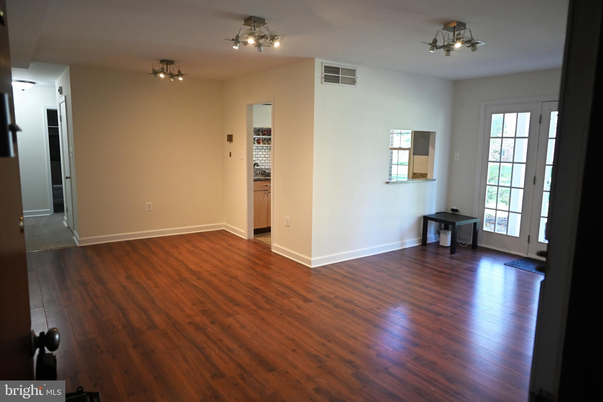 9451 Fairfax Boulevard, Unit 102 Fairfax, VA 22031 - Photo 6 of 26 an empty room with wooden floor and windows
