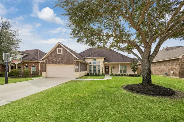 a front view of a house with a garden and trees
