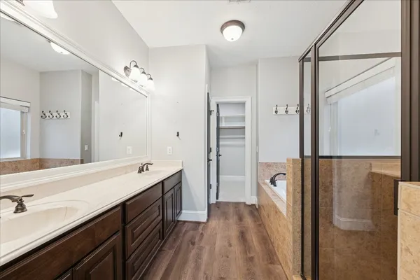 a spacious bathroom with a double vanity sink a mirror and shower