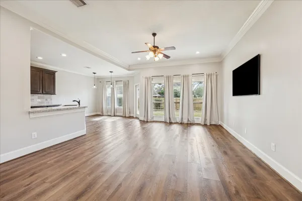 a view of an empty room with a kitchen and a window