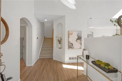 a hallway with white cabinets and wooden floor