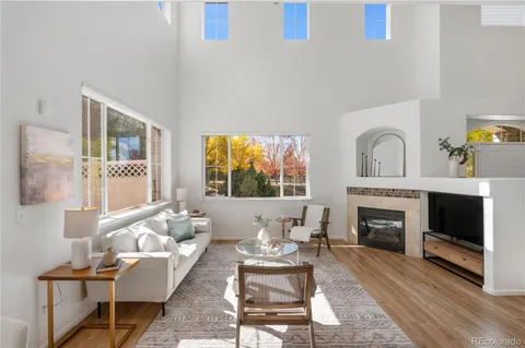 a living room with furniture a fireplace and a large window