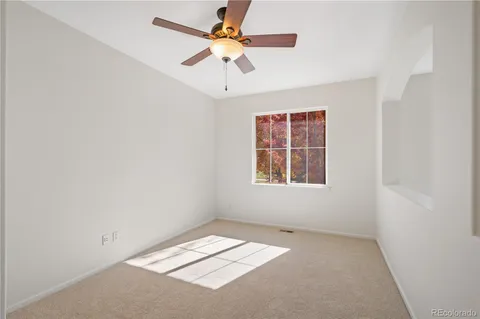 an empty room with a window and a fan