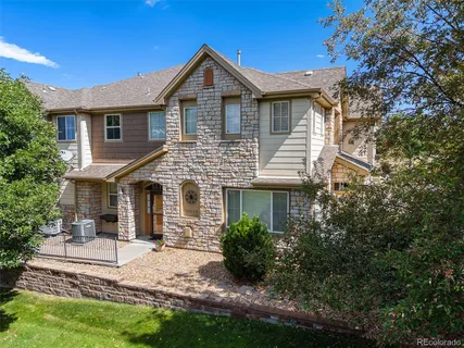 a view of a house with a yard and potted plants