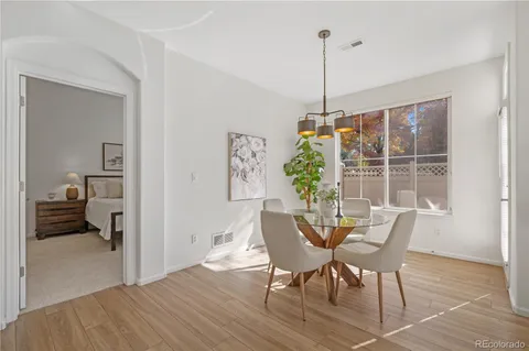 a dining room with furniture window and wooden floor