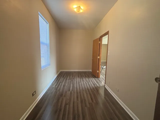 a view of a small space with wooden floor and a window