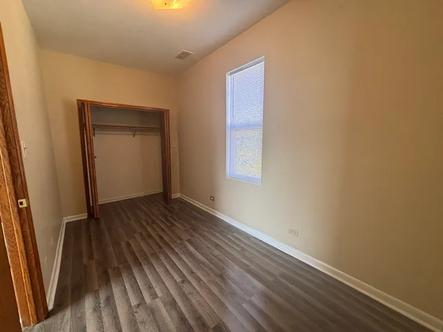 an empty room with wooden floor and a window