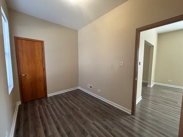 an empty room with wooden floor and closet