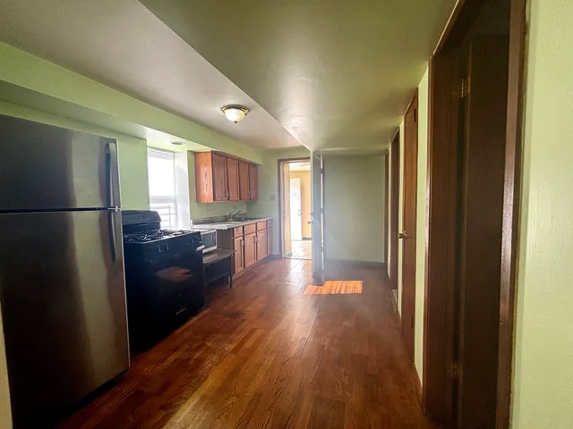 a view of a hallway with wooden floor and furniture