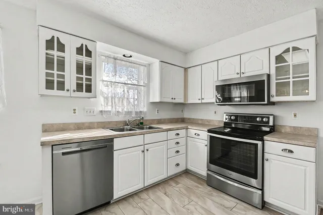 a kitchen with stainless steel appliances granite countertop a stove microwave and sink