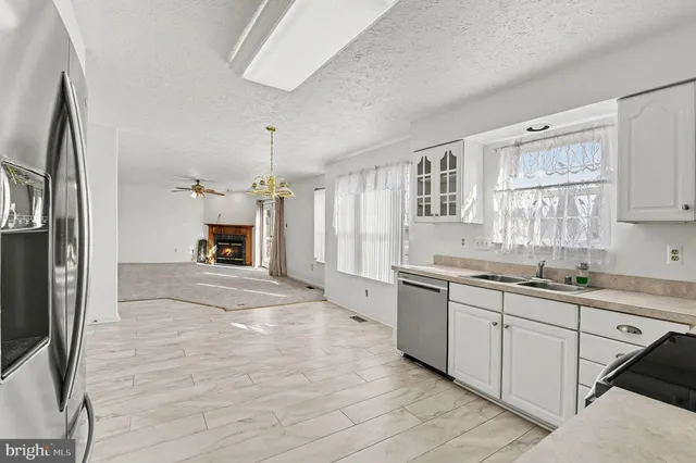 a large kitchen with kitchen island a sink stainless steel appliances and cabinets