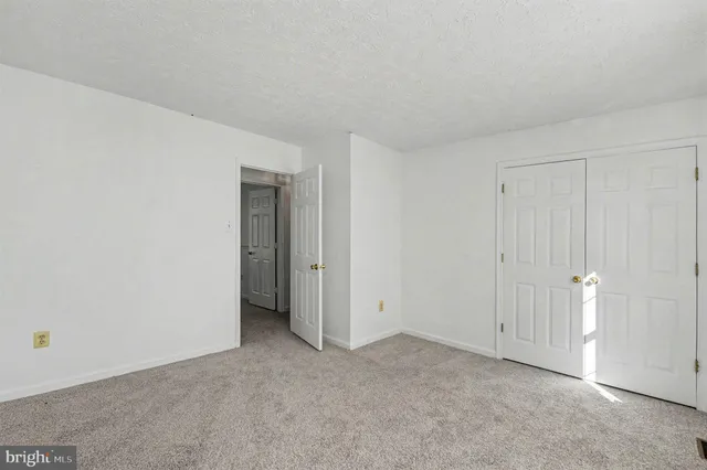 a view of an empty room and closet area