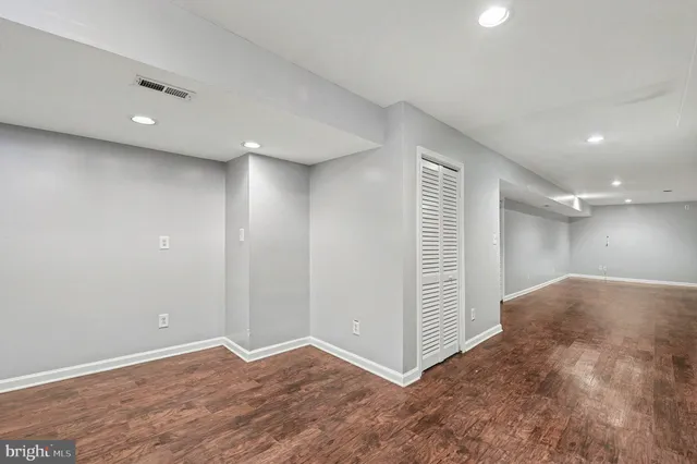 an empty room with wooden floor and white walls