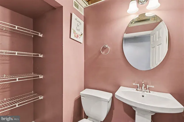 a bathroom with a toilet sink and mirror