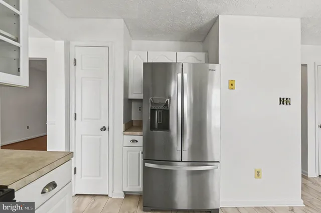 a metallic refrigerator freezer sitting in a kitchen