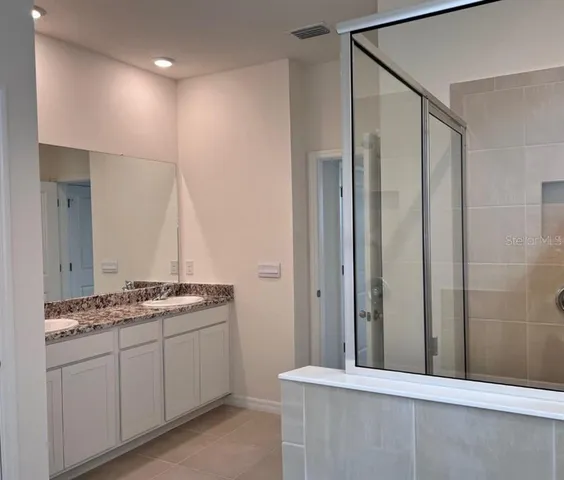 a bathroom with a granite countertop sink and a mirror