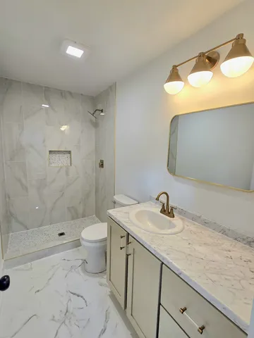 a bathroom with a sink a toilet and shower