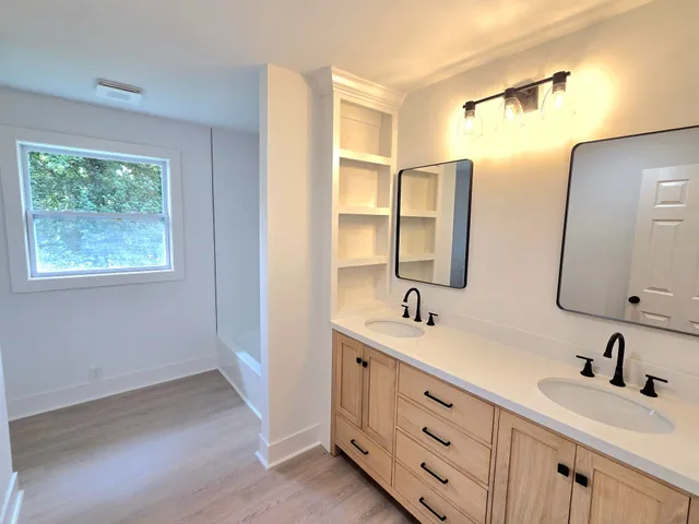 a bathroom with double vanity and a mirror