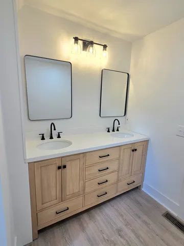 a bathroom with double sink and a mirror