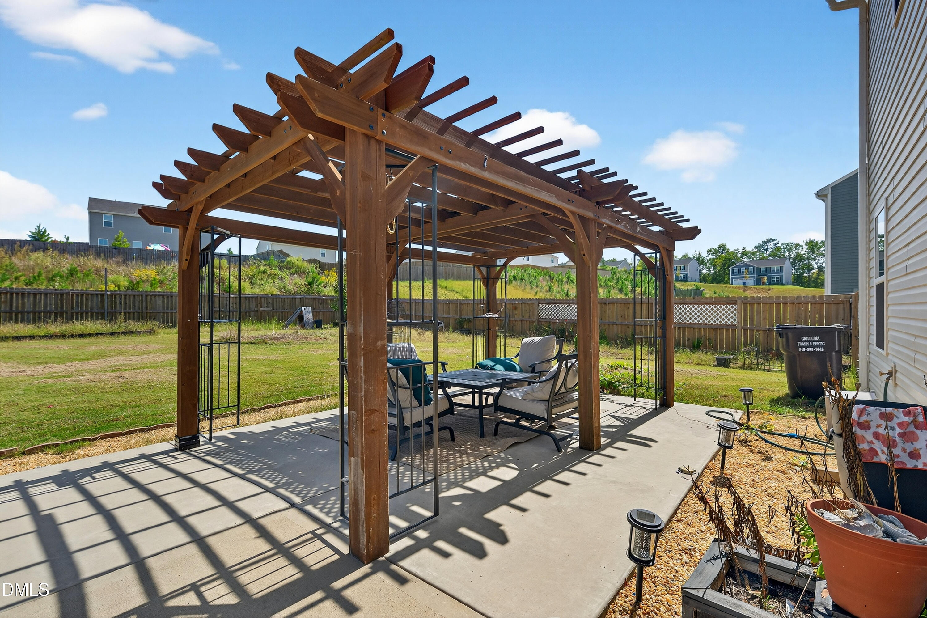 125 Donatella Way Angier, NC 27501 - Photo 9 of 10 a view of a patio with lawn chairs floor to ceiling window next to a yard