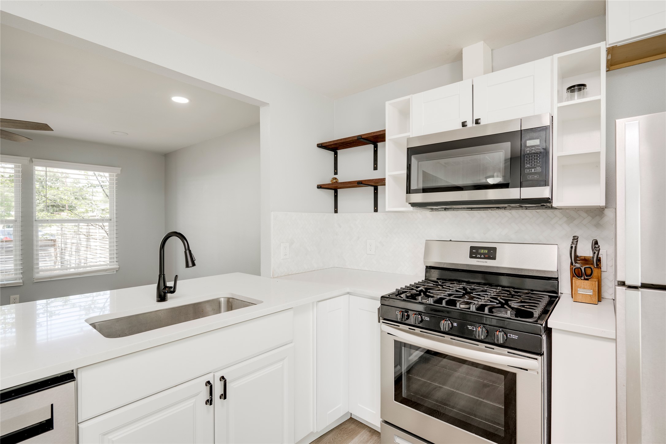 1400 Marcus Place, Unit B Austin, TX 78721 - Photo 28 of 39 Modern kitchen features bright white cabinetry, sleek countertops, and stainless steel appliances.