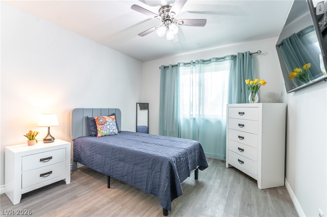 105 South Cimarron Road Las Vegas, NV 89145 - Photo 18 of 28 Smooth walls and classic wood-look flooring establish a clean, restful bedroom atmosphere.