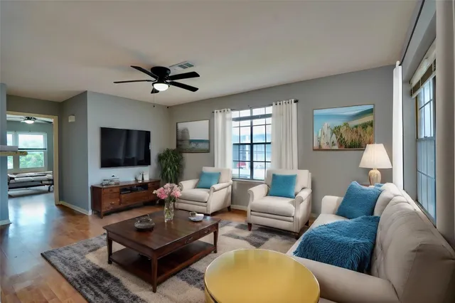 a living room with furniture a flat screen tv and a large window