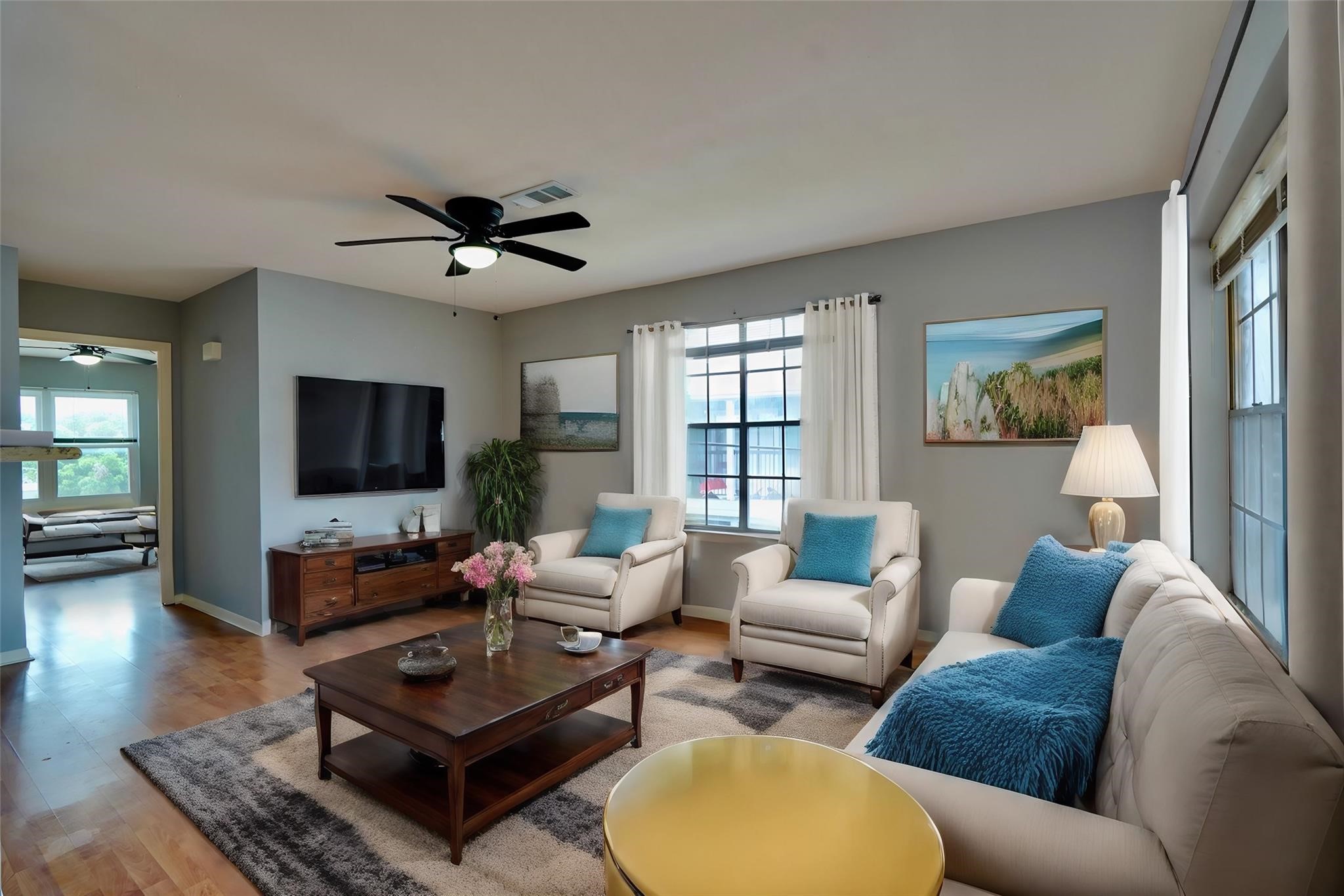 a living room with furniture a flat screen tv and a large window