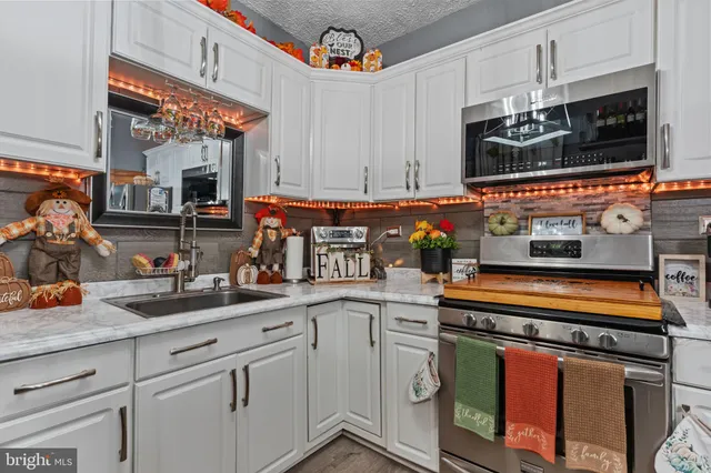 a kitchen with stainless steel appliances granite countertop a sink and cabinets