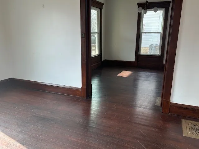 a view of empty room with wooden floor and fan